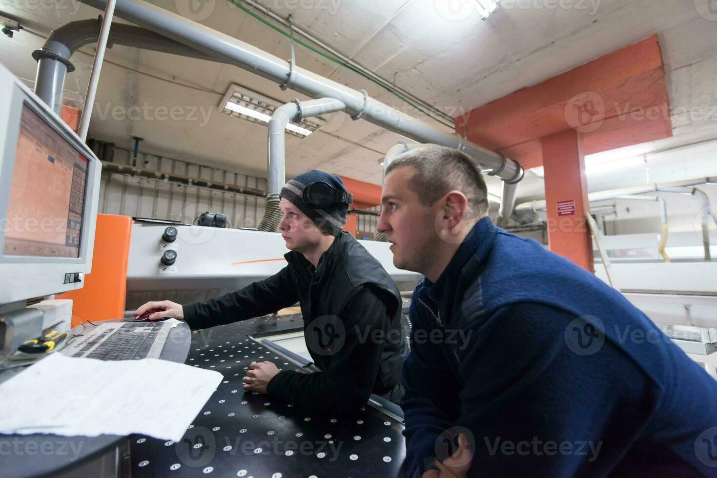 carpenters calculating and programming a cnc wood working machine photo