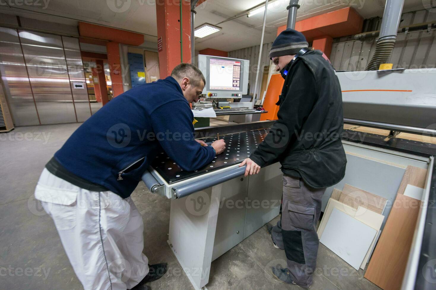 carpenters calculating and programming a cnc wood working machine photo