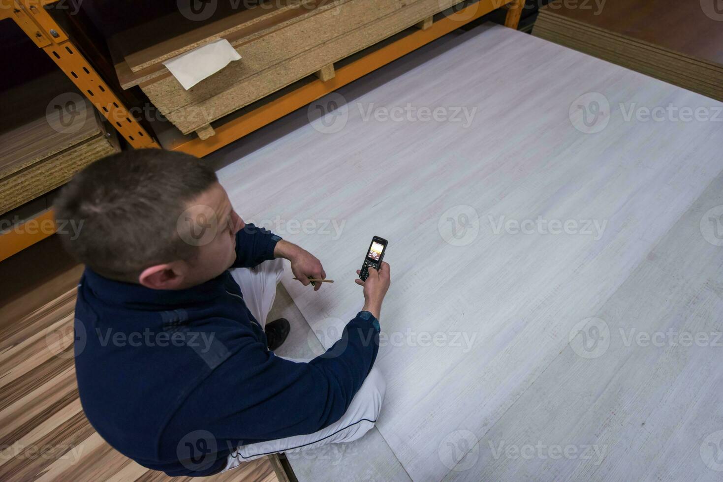 carpenter using a mobile phone to calculate measures photo