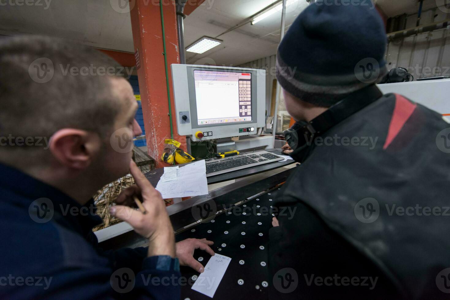 carpenters calculating and programming a cnc wood working machine photo