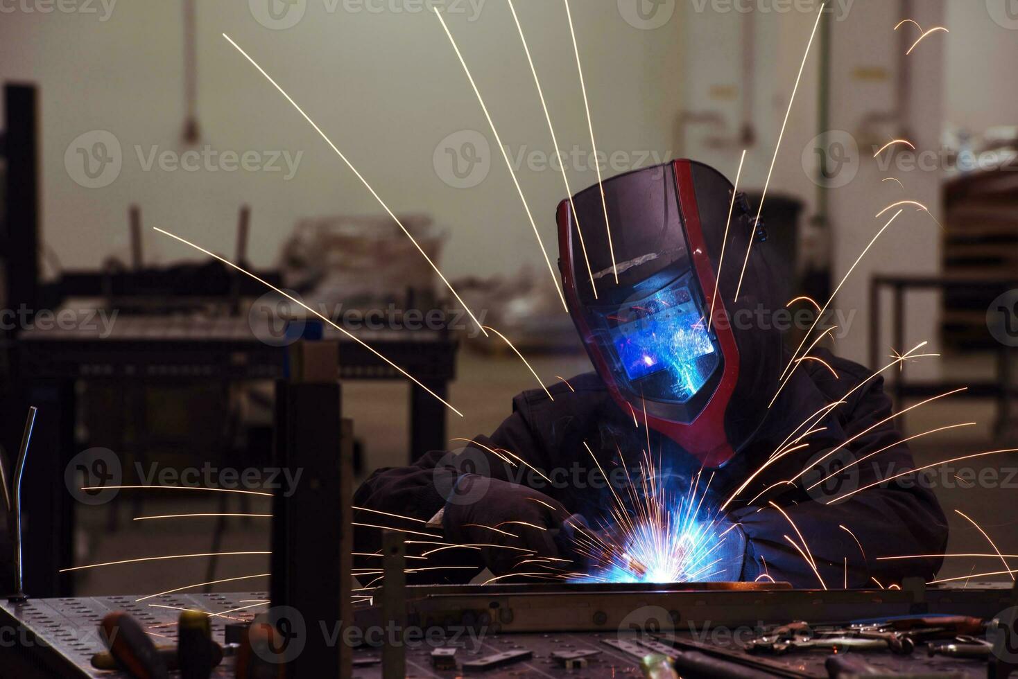 Professional Heavy Industry Welder Working Inside factory, Wears Helmet and Starts Welding. Selective Focus photo