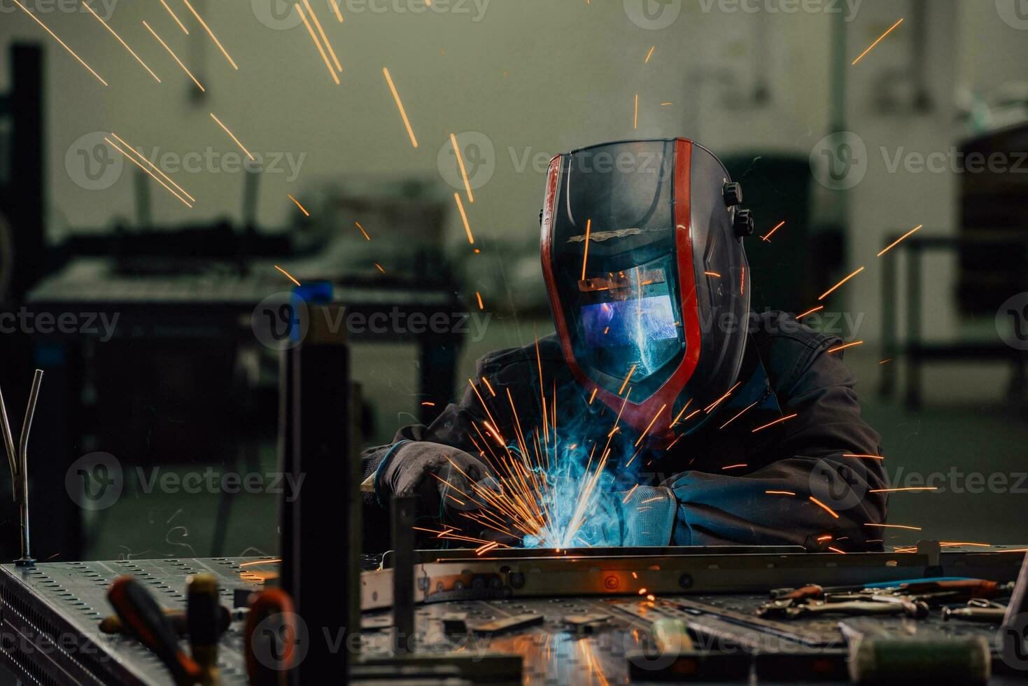 Professional Heavy Industry Welder Working Inside factory, Wears Helmet and Starts Welding. Selective Focus photo