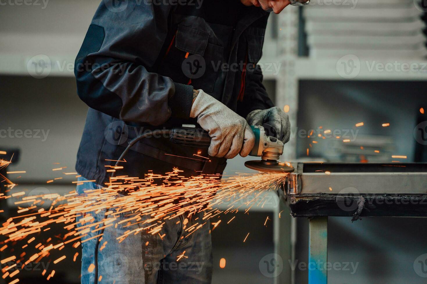Heavy Industry Engineering Factory Interior with Industrial Worker Using Angle Grinder and Cutting a Metal Tube. Contractor in Safety Uniform and Hard Hat Manufacturing Metal Structures. photo