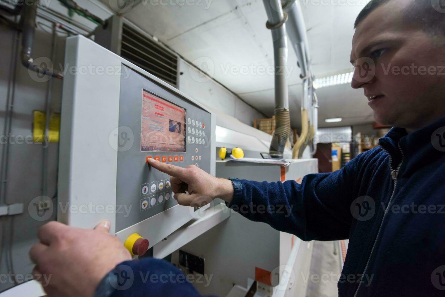 carpenter calculating and programming a cnc wood working machine photo