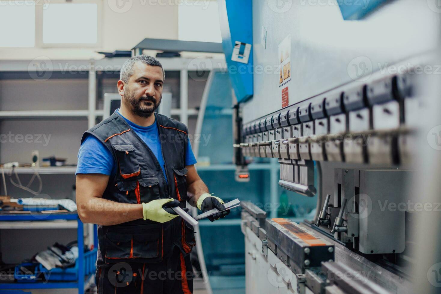 A smart factory worker or engineer makes machines in a production workshop. The concept of industry and engineering. Selective focus photo
