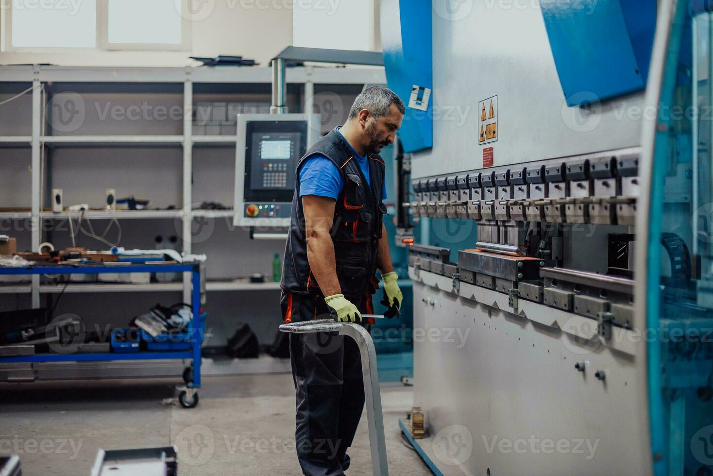 A smart factory worker or engineer makes machines in a production workshop. The concept of industry and engineering. Selective focus photo