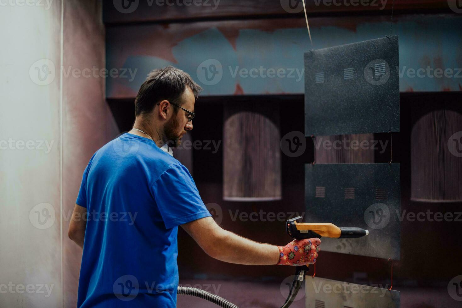 The painter paints the iron element. Industrial painting parts. Metal designs photo