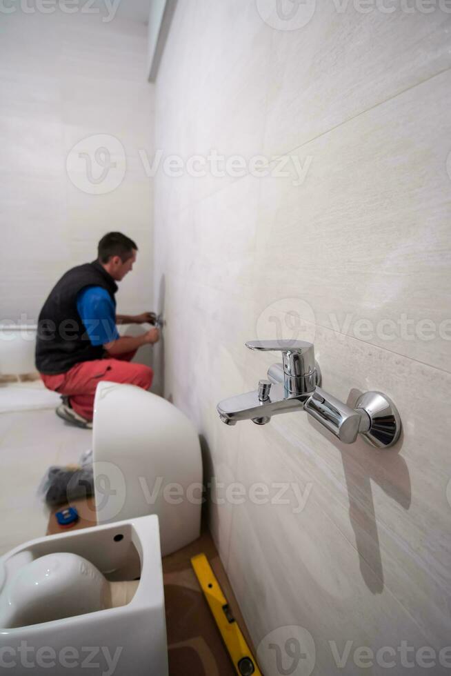 professional plumber working in a bathroom photo