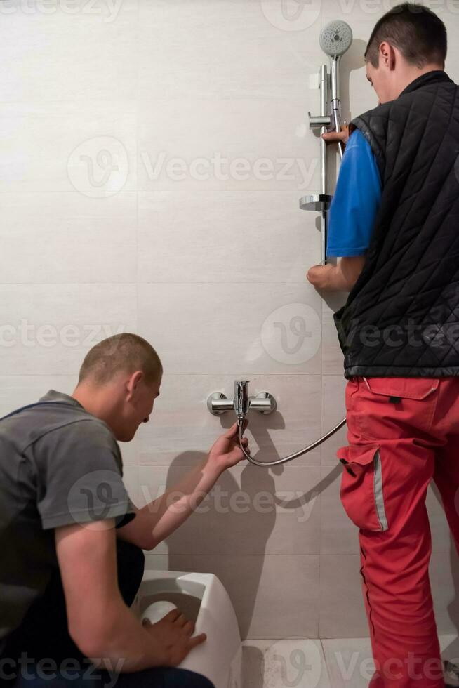 professional plumbers working in a bathroom photo