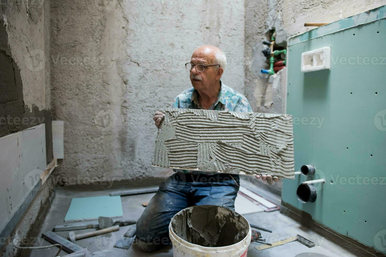 worker installing big ceramic tiles photo