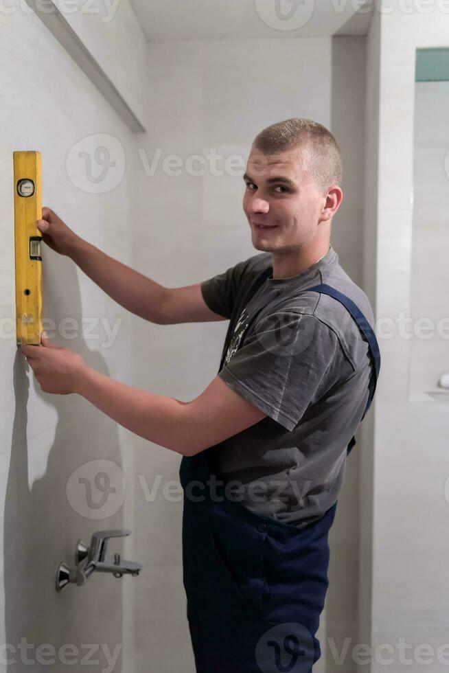 professional plumber using bubble level in a bathroom photo