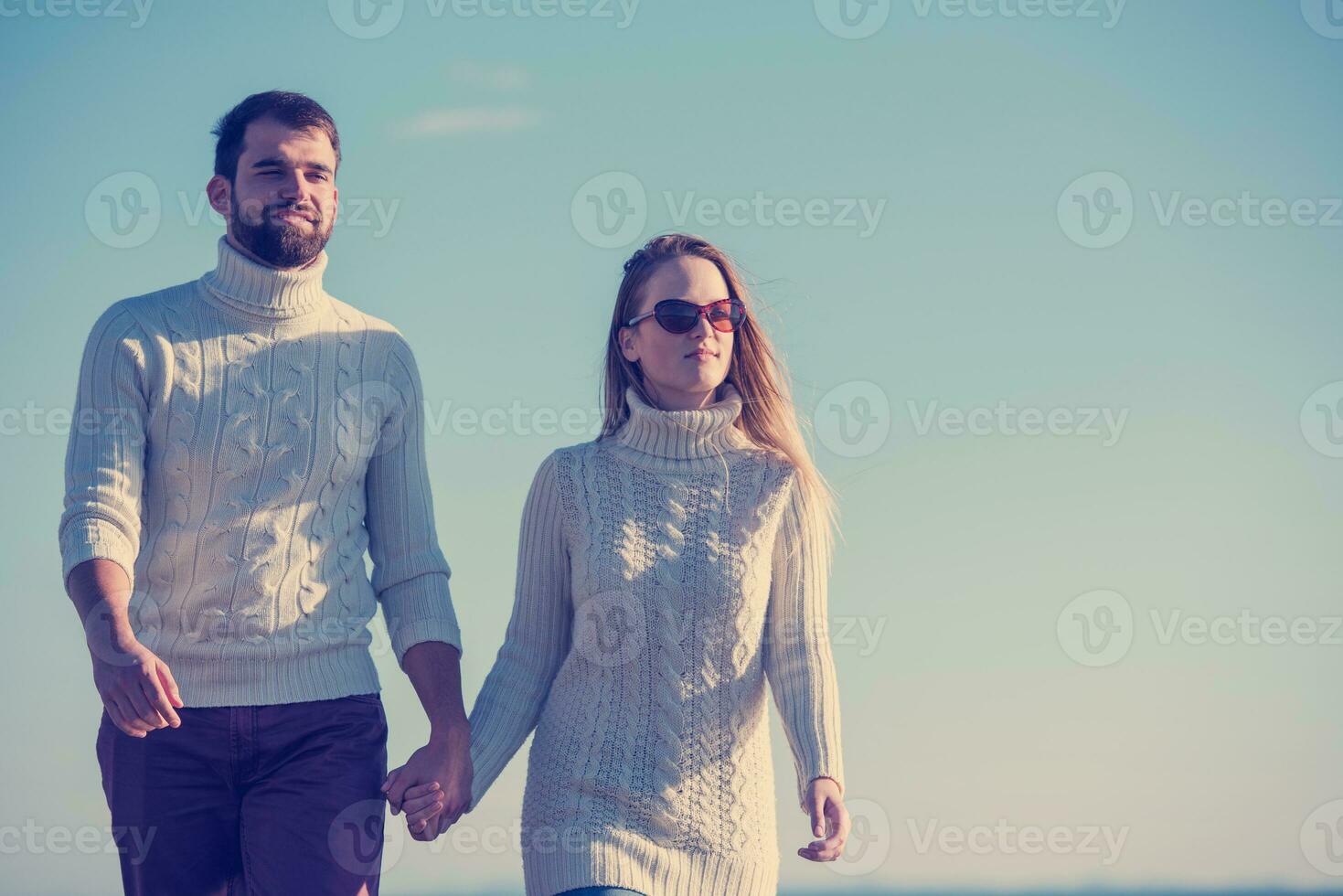 Loving young couple on a beach at autumn sunny day photo