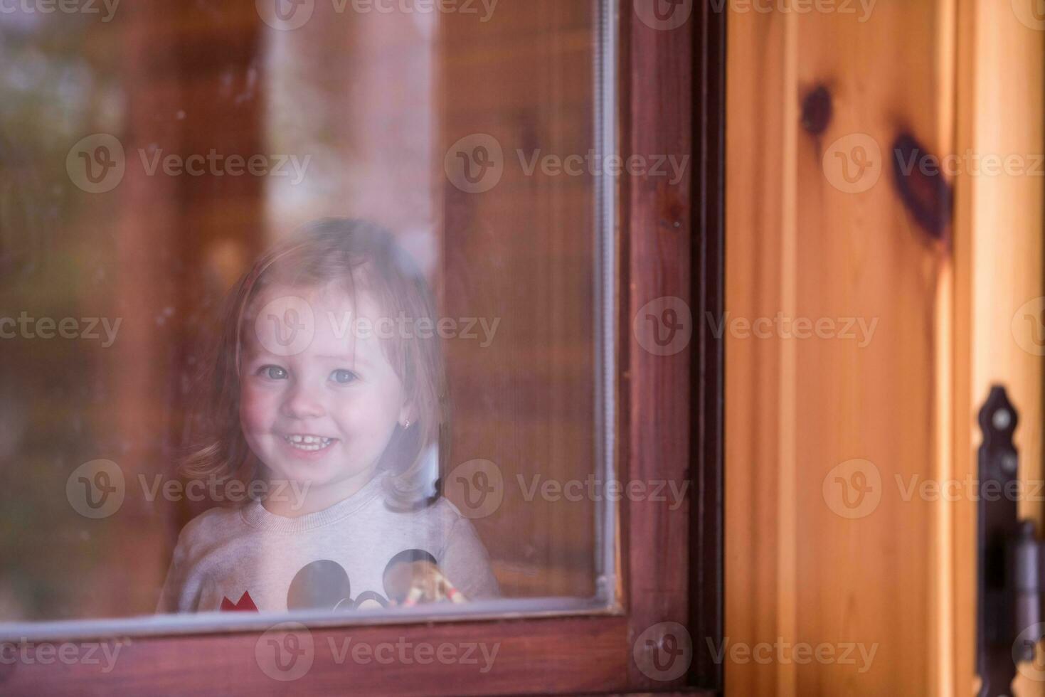 little cute girl playing near the window photo