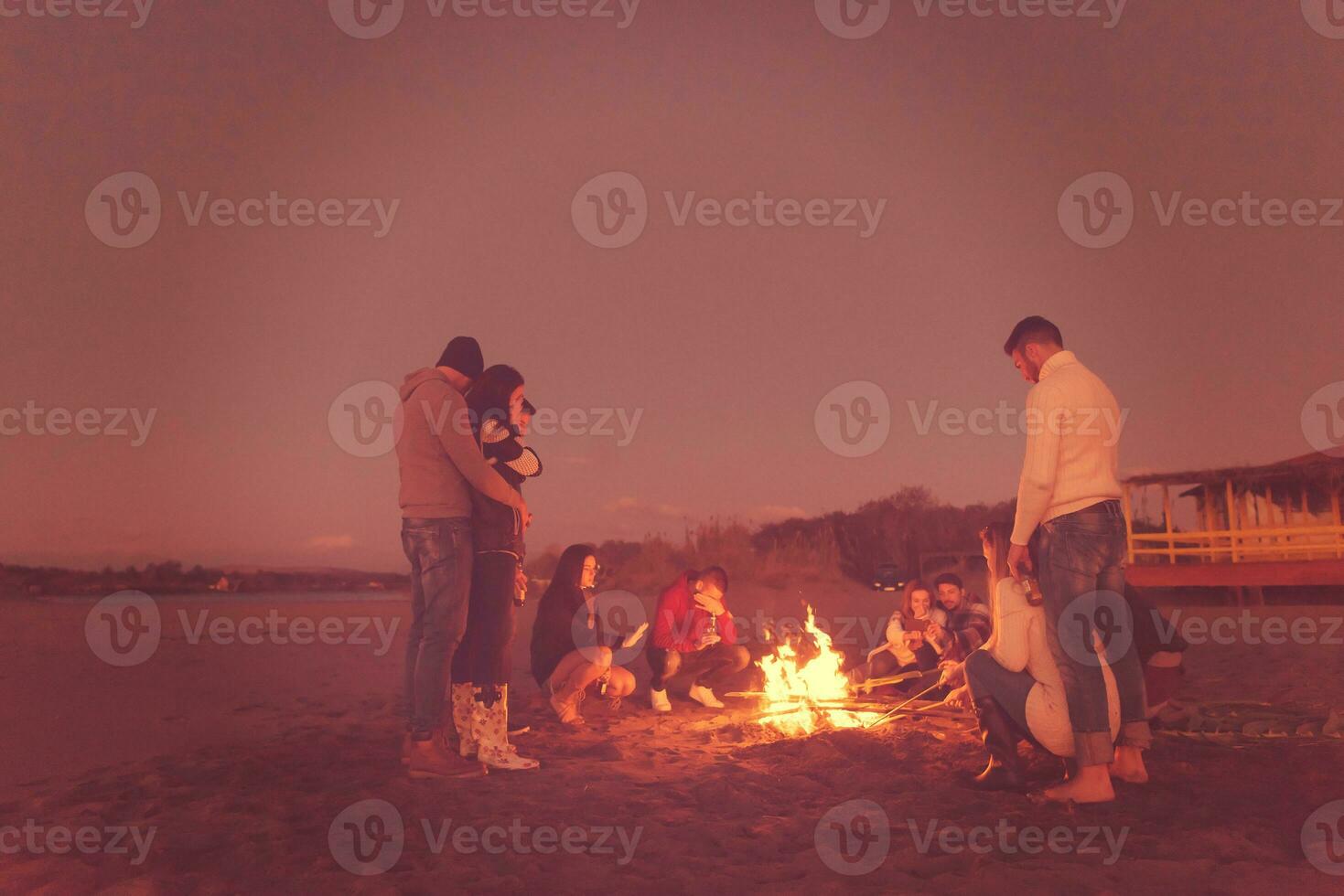 Friends having fun at beach on autumn day photo