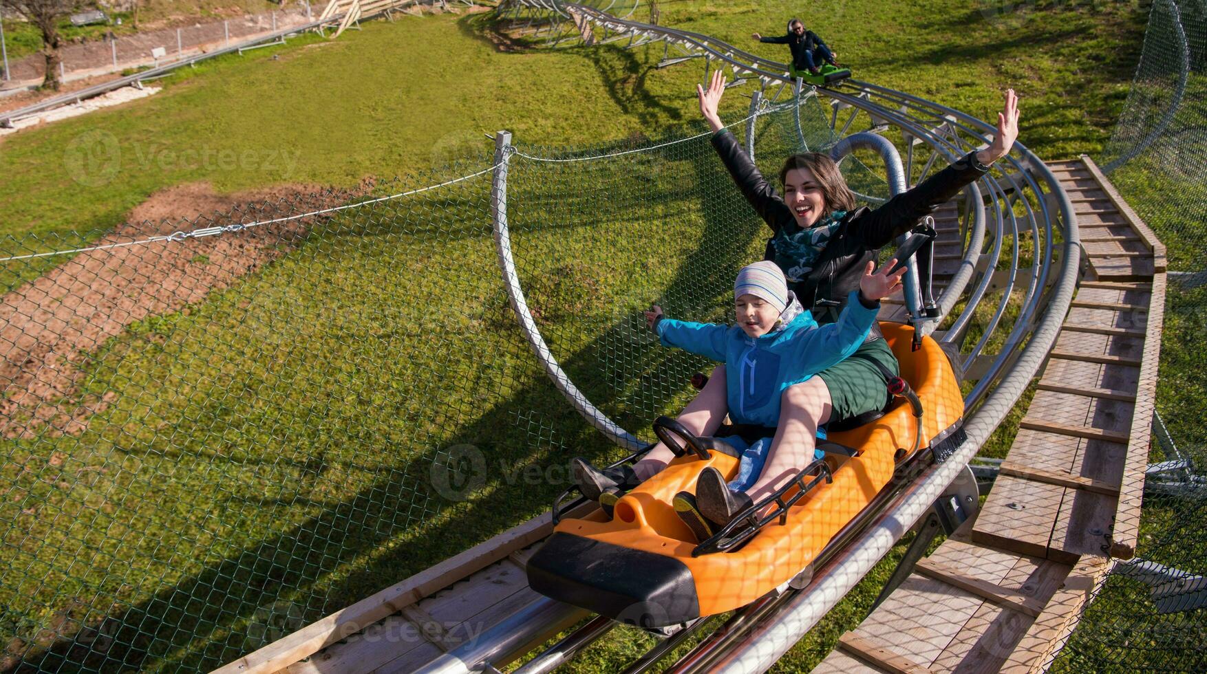 young mother and son driving alpine coaster photo