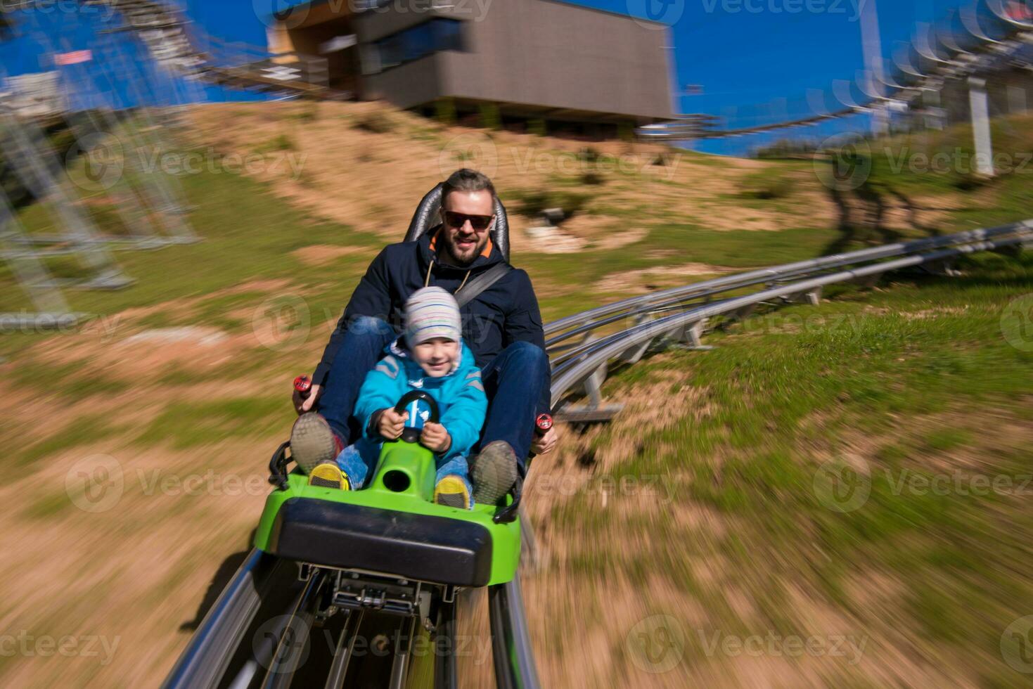 young father and son driving alpine coaster photo