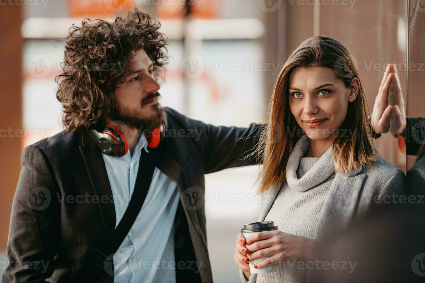 Two serious businessmen drinking coffee to take away. Man and middle-aged woman in official shirt standing outside. Coffee break concept photo