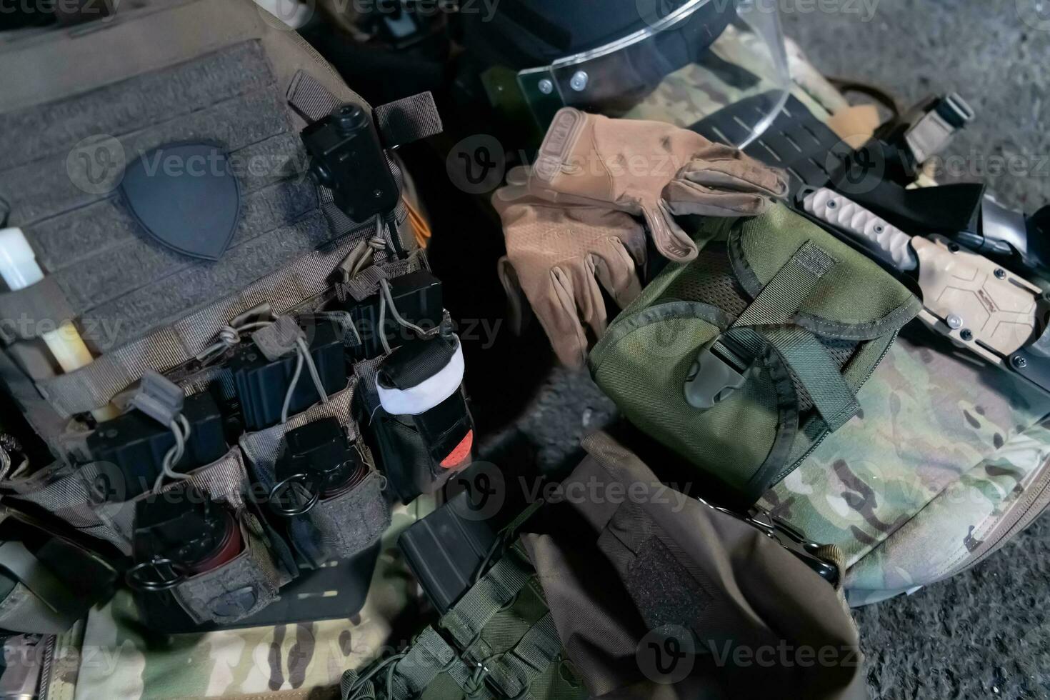 Army body armor, helmet and ammunition, Kalashnikov assault rifle with matrons and first aid tourniquet composition on brown wood. Army body armor. flat laying. military concept. photo