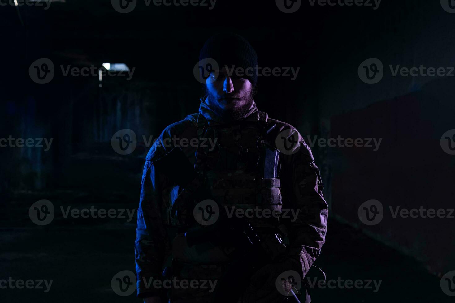 Ejército soldado en combate uniformes con un asalto rifle y combate casco noche misión oscuro antecedentes. azul y púrpura gel ligero efecto. foto