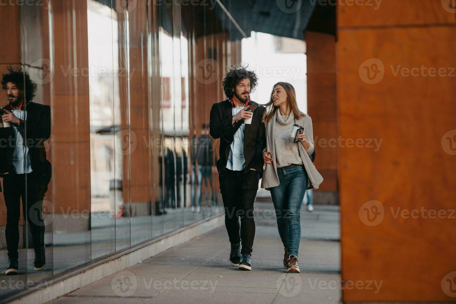 Business man and business woman talking and holding luggage traveling on a business trip, carrying fresh coffee in their hands.Business concept photo