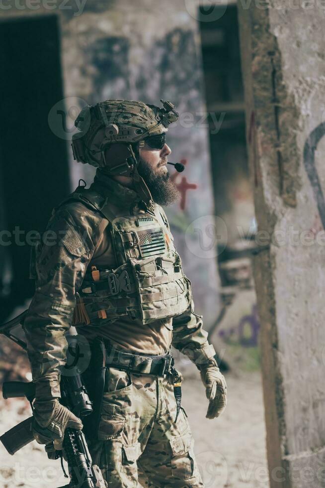 A bearded soldier in uniform of special forces in a dangerous military action in a dangerous enemy area. Selective focus photo