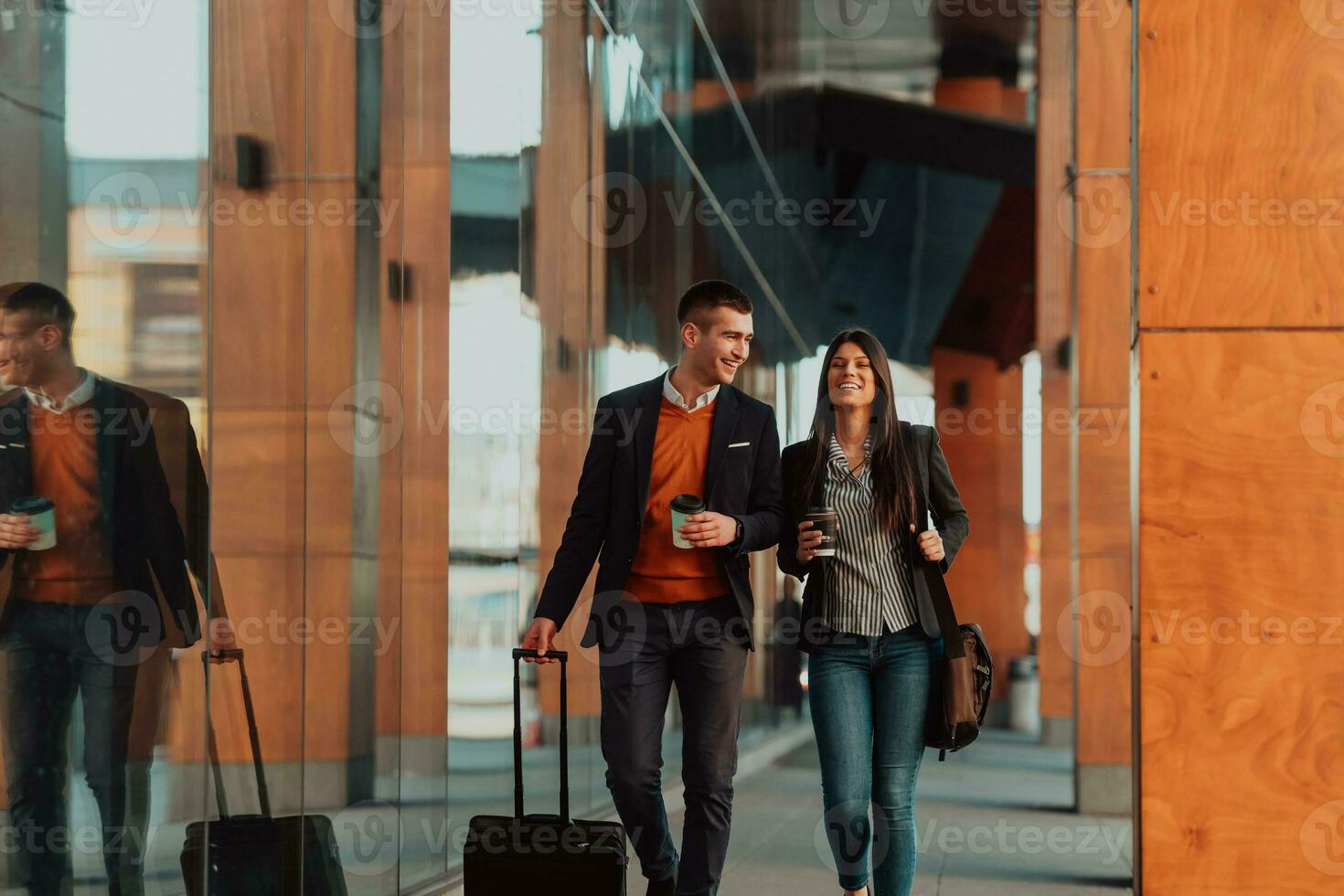 Two businessmen walk around town drinking coffee photo