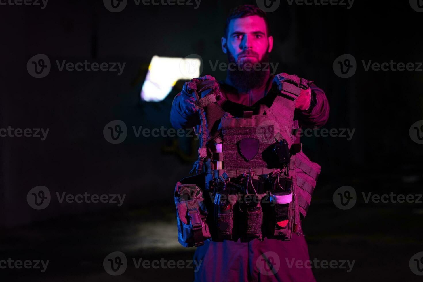 Army soldier in Combat Uniforms with an assault rifle and combat helmet night mission dark background. Blue and purple gel light effect. photo
