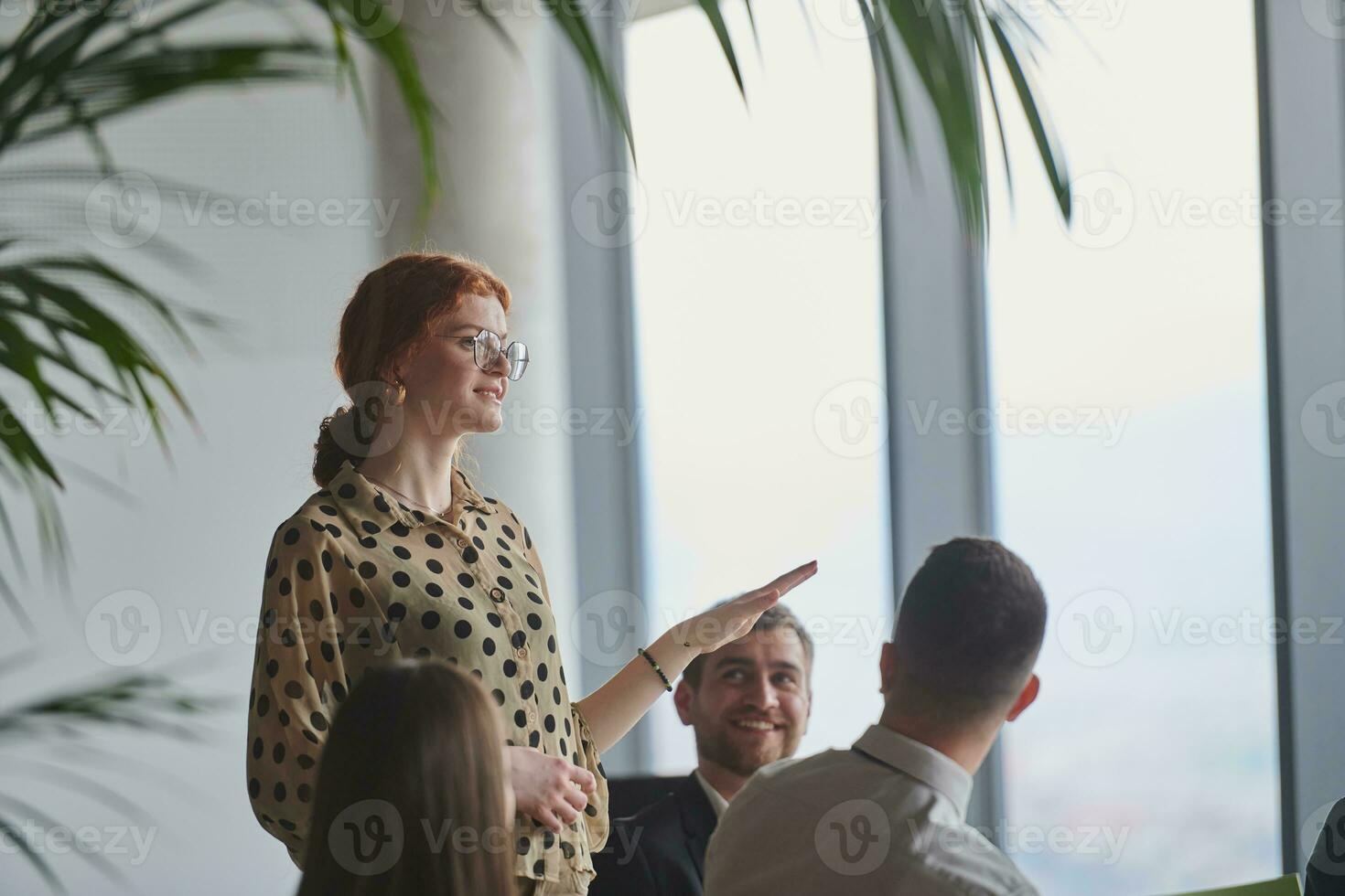 A group of young business professionals in a modern office attentively listens to colleague presentation, showcasing a dynamic and collaborative atmosphere as they exchange ideas and strive for success. photo