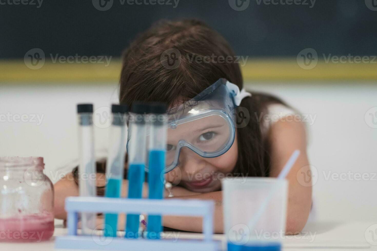 Elementary School Science Classroom Little girl Mixes Chemicals in Beakers. Children Learn with Interest photo