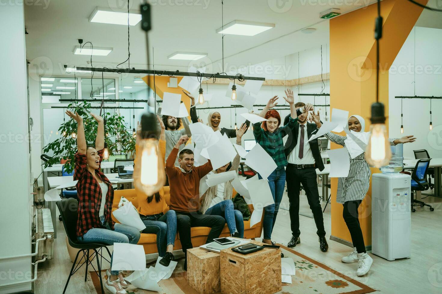 Group of business people throwing paper in air at modern startup office, team success and job done concept photo