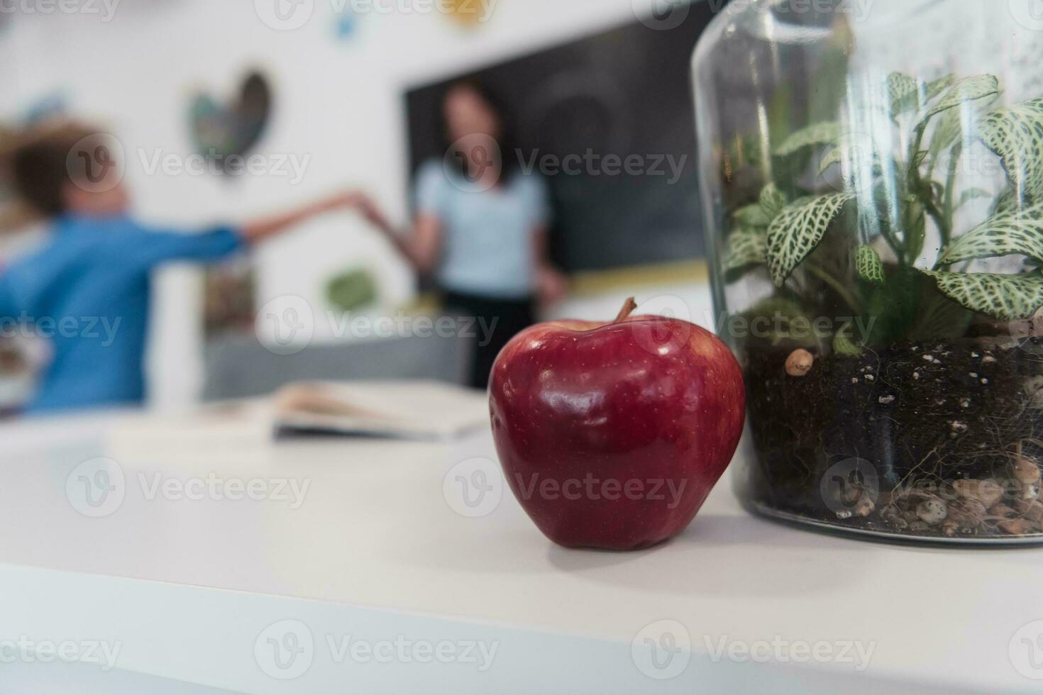Biology and biochemistry classes. A close-up photo of a bottle containing a green plant and a ripe apple next to the bottle