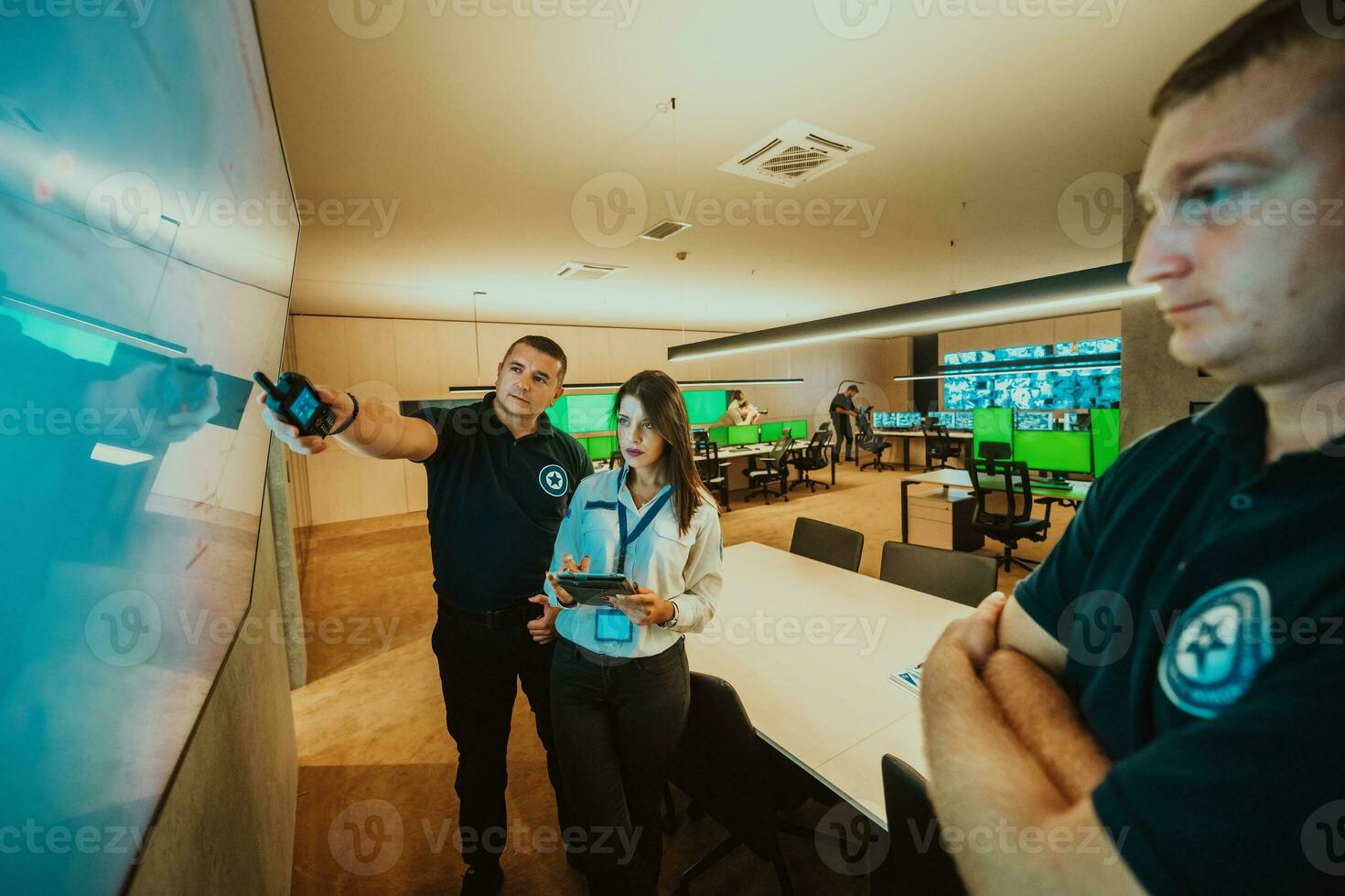 Group of Security data center operators working in a CCTV monitoring room looking on multiple monitors Officers Monitoring Multiple Screens for Suspicious Activities Team working on the System Contr photo