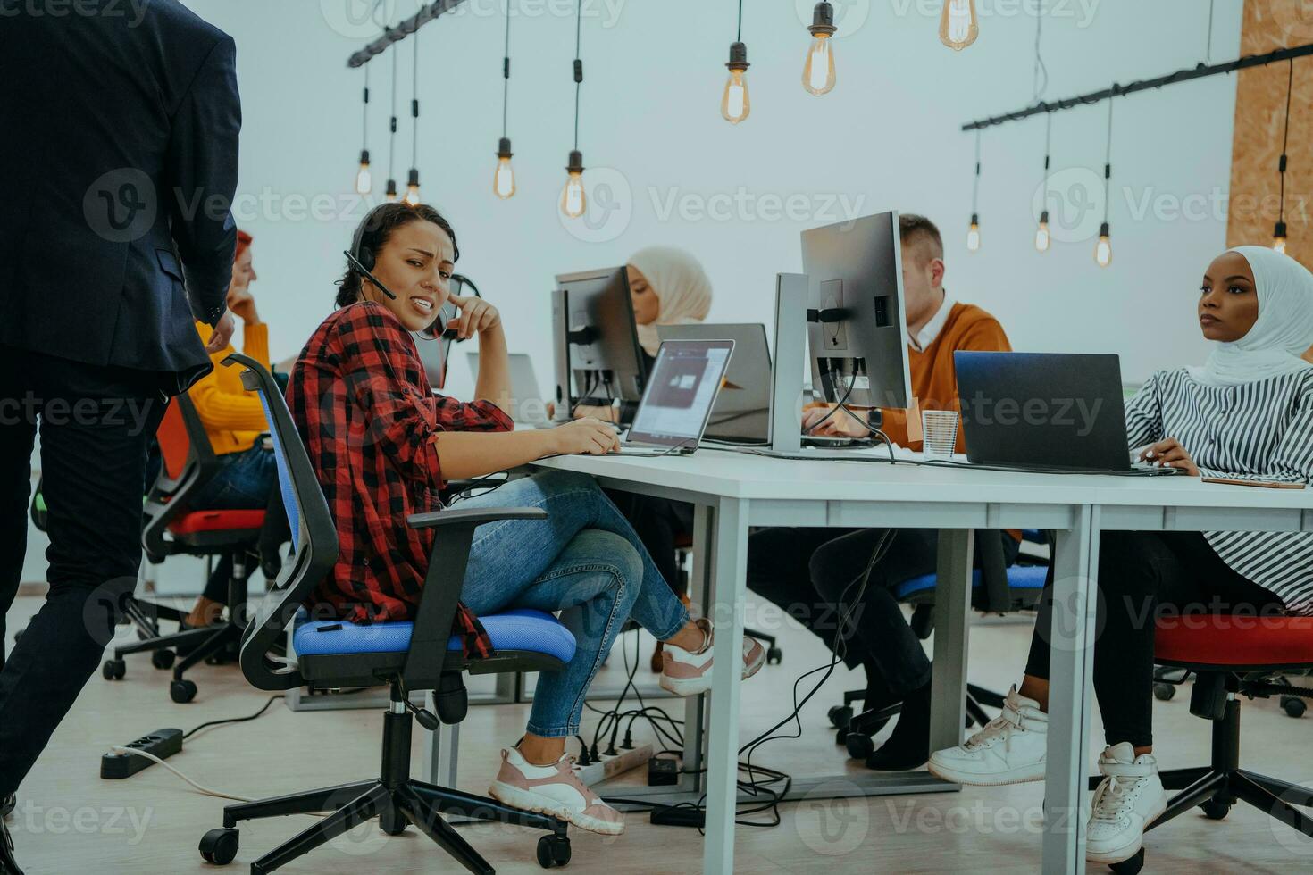 Group of multi-ethnic colleagues working on desktop computers, laptop and sharing their ideas in a modern office space.Young influencers work on online marketing projects. photo