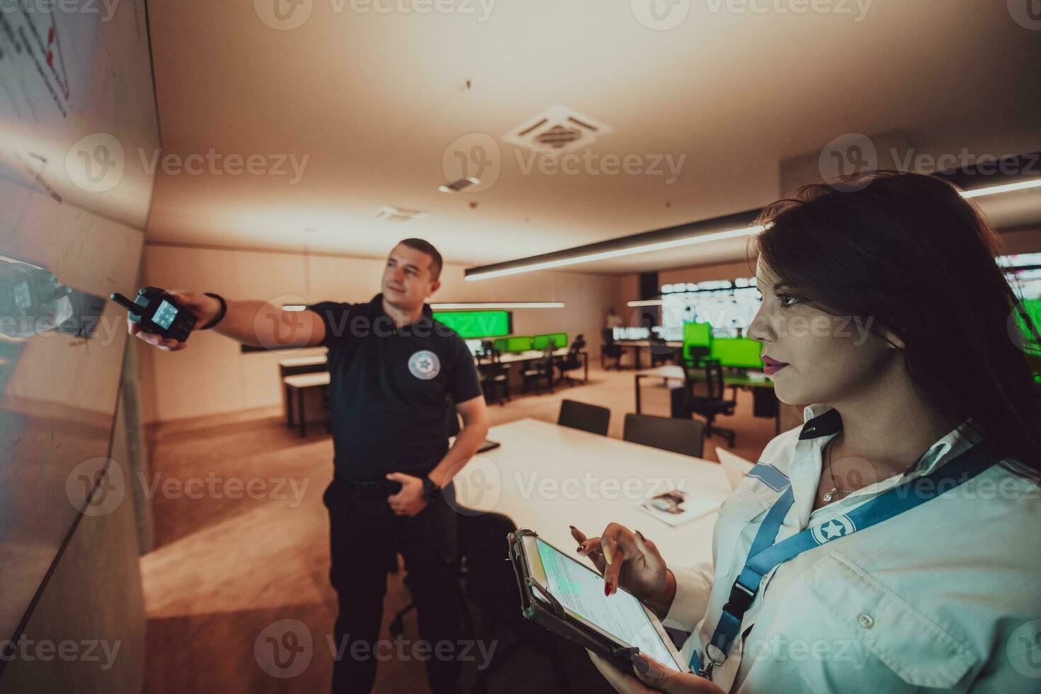 Group of Security data center operators working in a CCTV monitoring room looking on multiple monitors Officers Monitoring Multiple Screens for Suspicious Activities Team working on the System Contr photo
