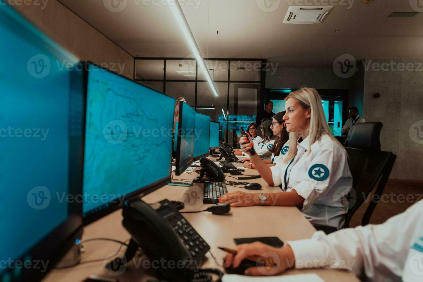 Group of female security operators working in a data system control room Technical Operators Working at workstation with multiple displays, security guards working on multiple monitors in surveillan photo