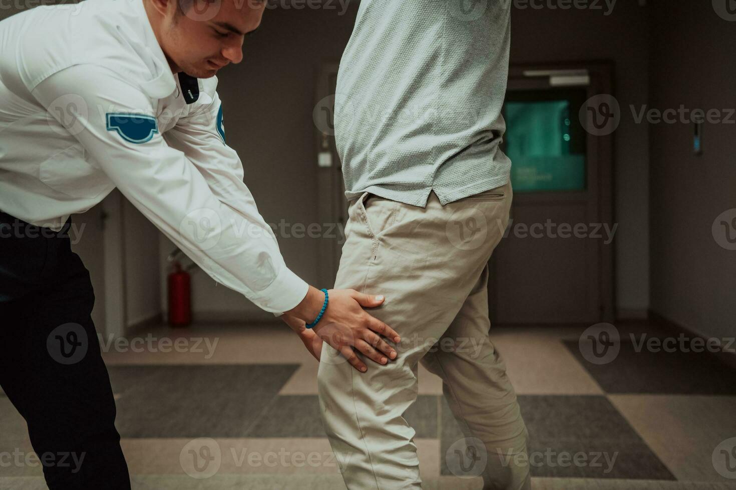 Security guard making body searching procedure on man for finding hidden objects before entering in treasury department photo