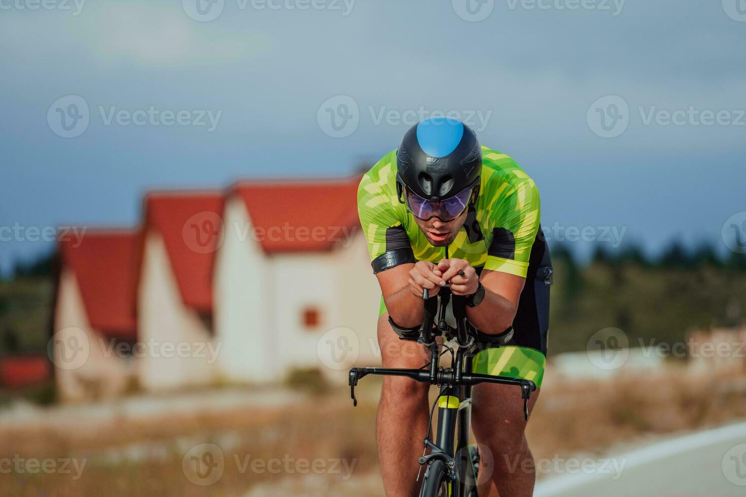 cerca arriba foto de un activo triatleta en ropa de deporte y con un protector casco montando un bicicleta. selectivo atención