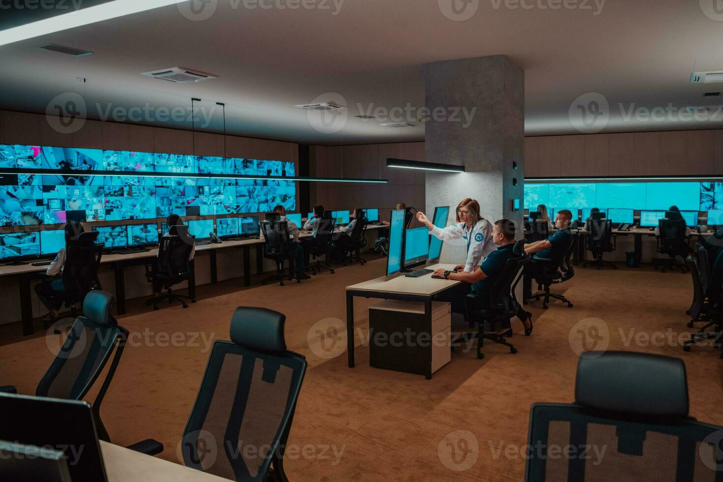 Group of Security data center operators working in a CCTV monitoring room looking on multiple monitors Officers Monitoring Multiple Screens for Suspicious Activities Team working on the System Contr photo