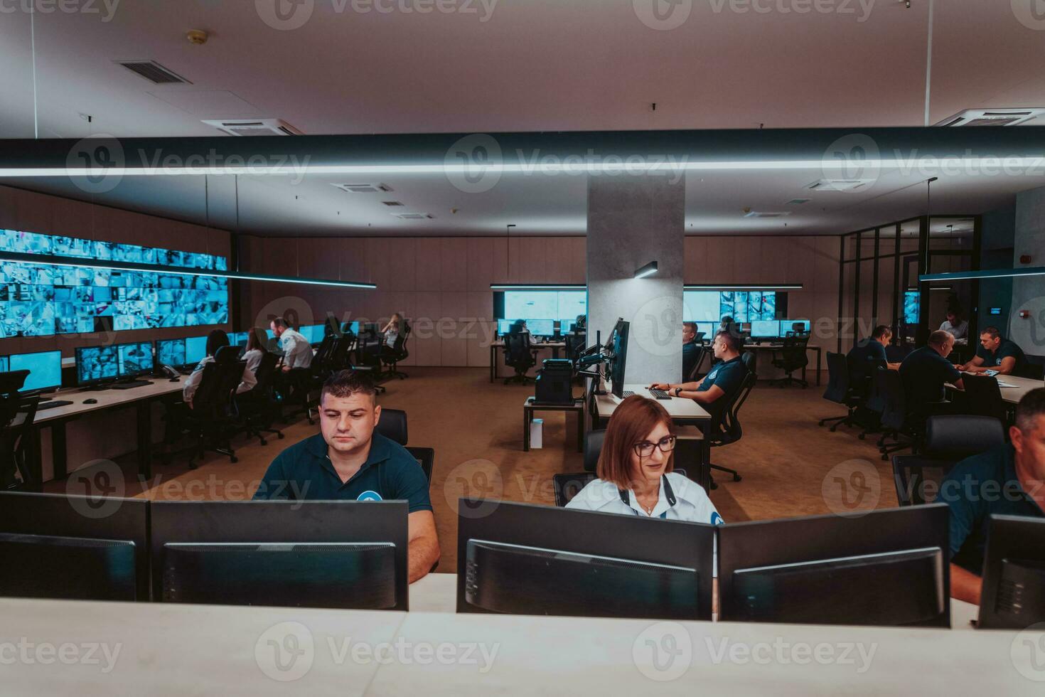 Group of Security data center operators working in a CCTV monitoring room looking on multiple monitors Officers Monitoring Multiple Screens for Suspicious Activities Team working on the System Contr photo