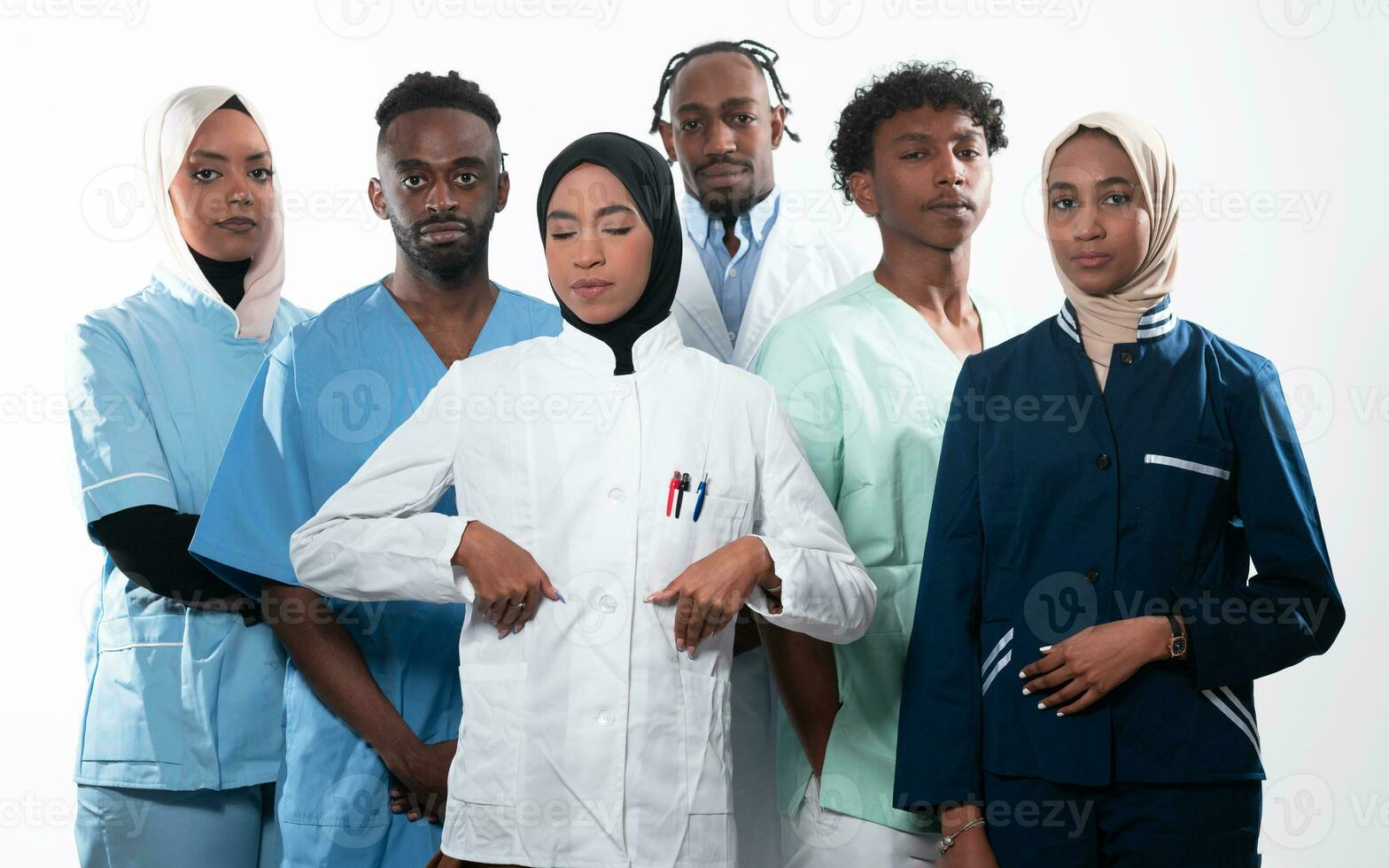 Team or group of a doctor, nurse and medical professional coworkers standing together. Portrait of diverse healthcare workers looking confident. Middle Eastern and African, Muslim medical team. photo