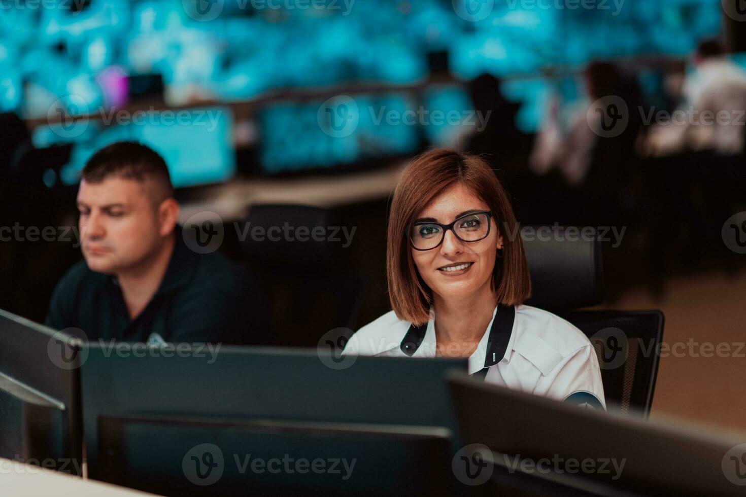 Female security operator working in a data system control room offices Technical Operator Working at workstation with multiple displays, security guard working on multiple monitors photo