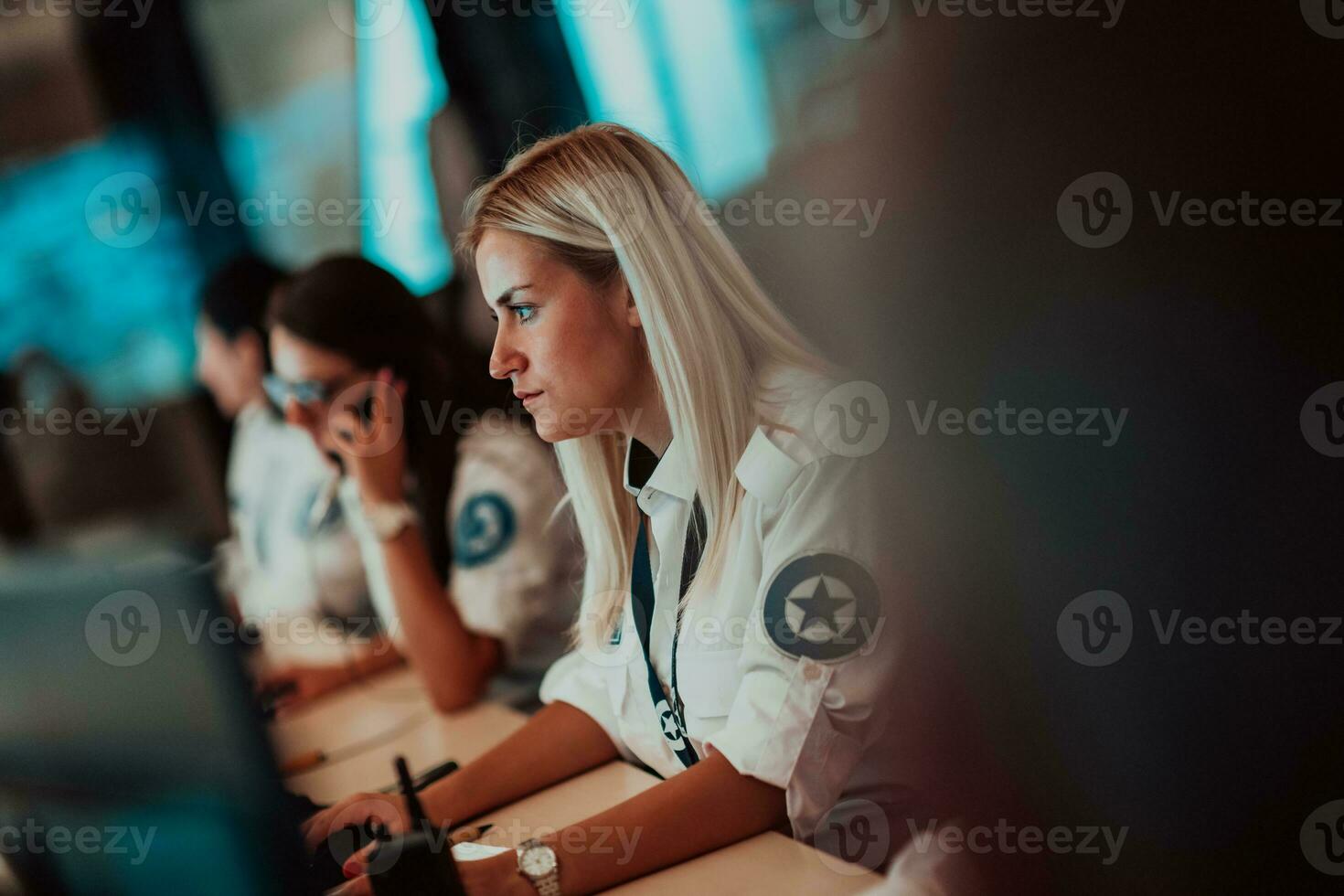 Female security operator working in a data system control room offices Technical Operator Working at workstation with multiple displays, security guard working on multiple monitors photo