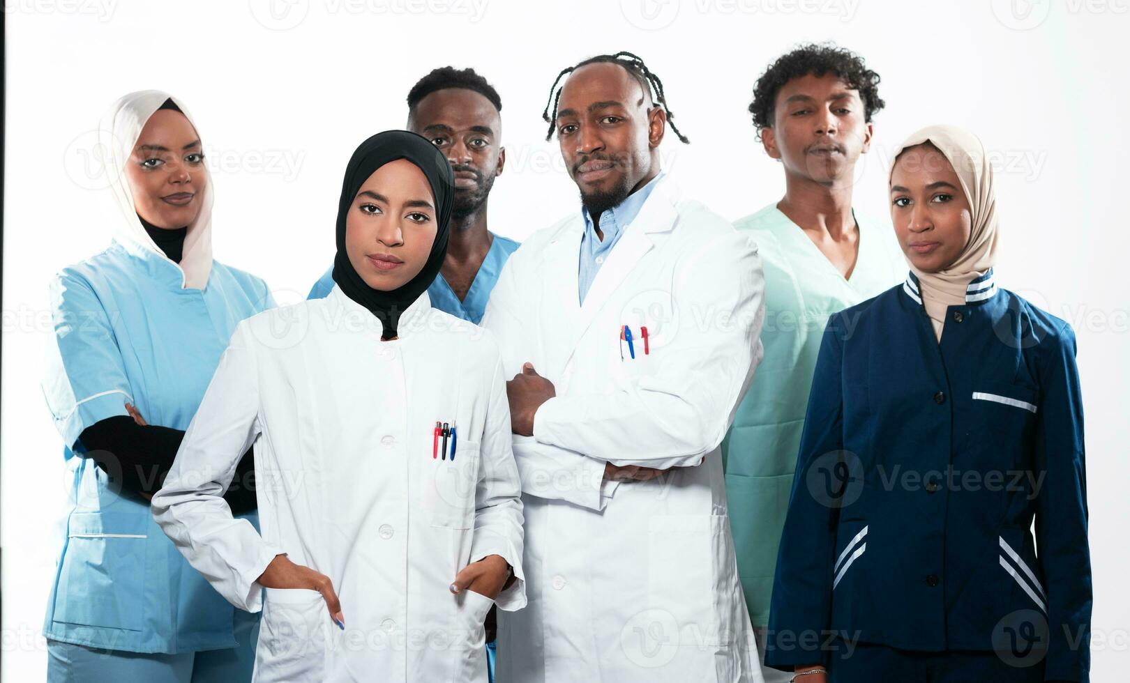 Team or group of a doctor, nurse and medical professional coworkers standing together. Portrait of diverse healthcare workers looking confident. Middle Eastern and African, Muslim medical team. photo