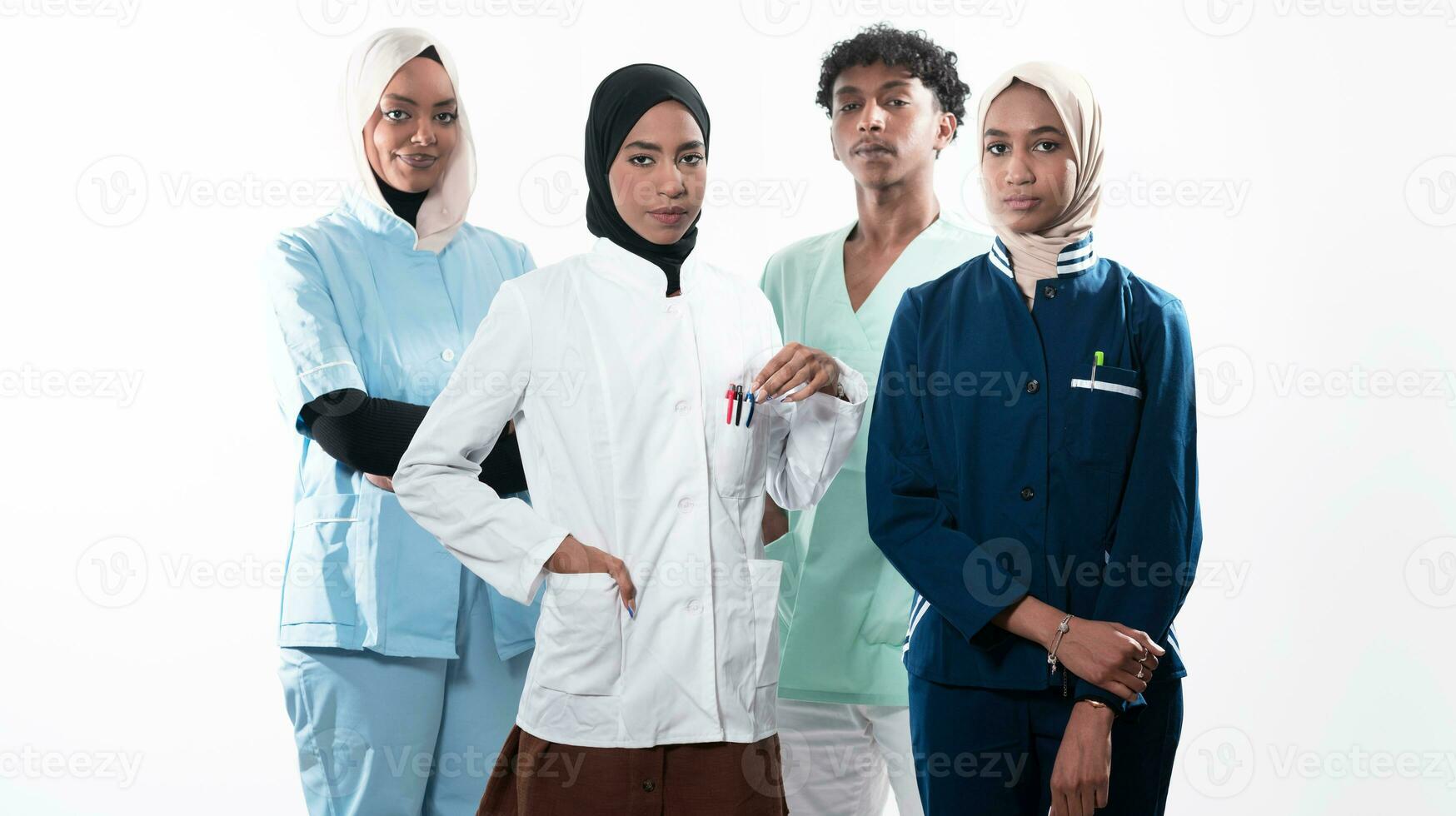 Closeup front view of group of mixed age doctors and nurses standing side by side and looking at the camera. Young Middle Eastern female in a team with African American male doctor. photo