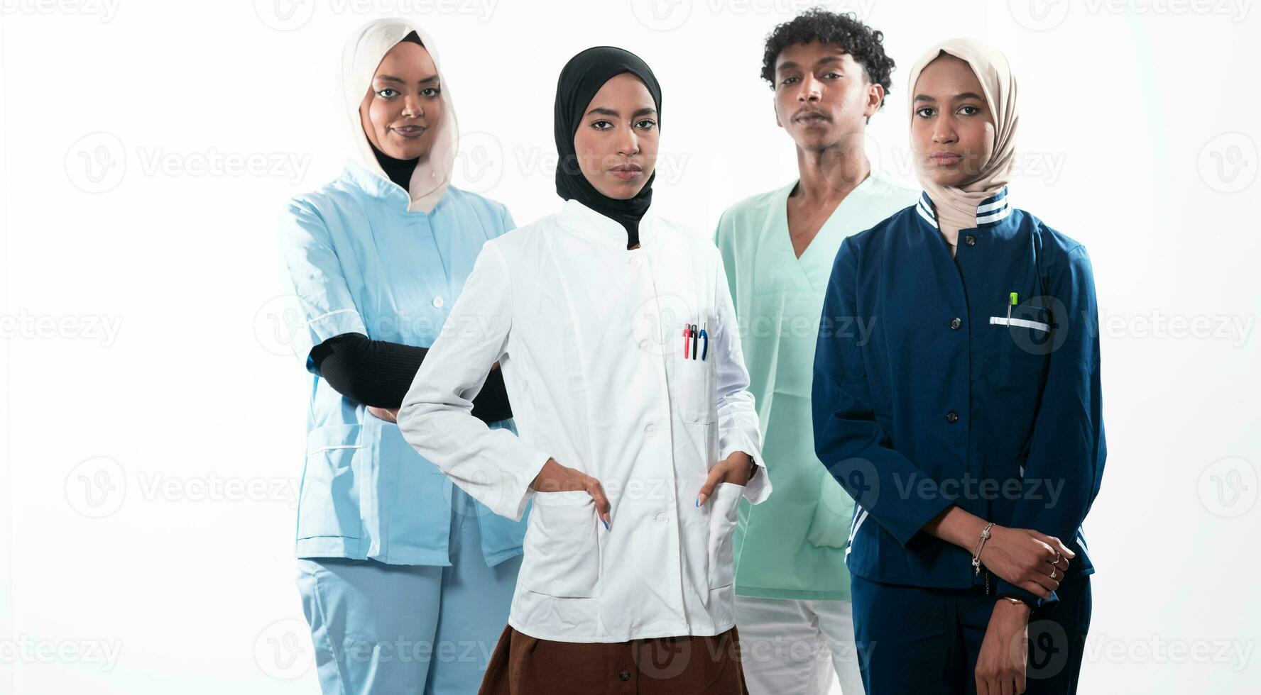 Closeup front view of group of mixed age doctors and nurses standing side by side and looking at the camera. Young Middle Eastern female in a team with African American male doctor. photo