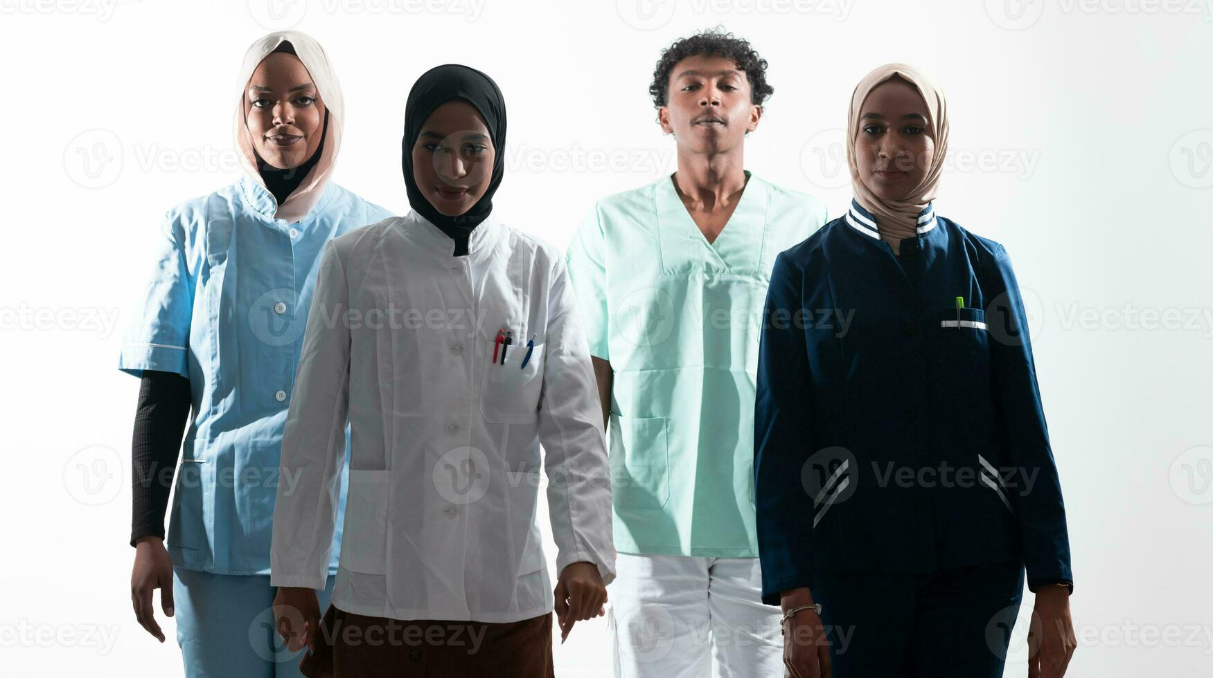 Closeup front view of group of mixed age doctors and nurses standing side by side and looking at the camera. Young Middle Eastern female in a team with African American male doctor. photo