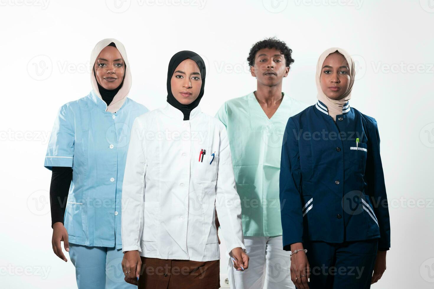 Closeup front view of group of mixed age doctors and nurses standing side by side and looking at the camera. Young Middle Eastern female in a team with African American male doctor. photo