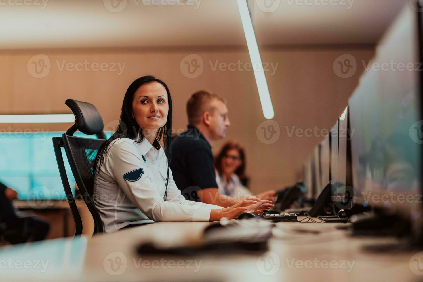 Female security operator working in a data system control room offices Technical Operator Working at workstation with multiple displays, security guard working on multiple monitors photo