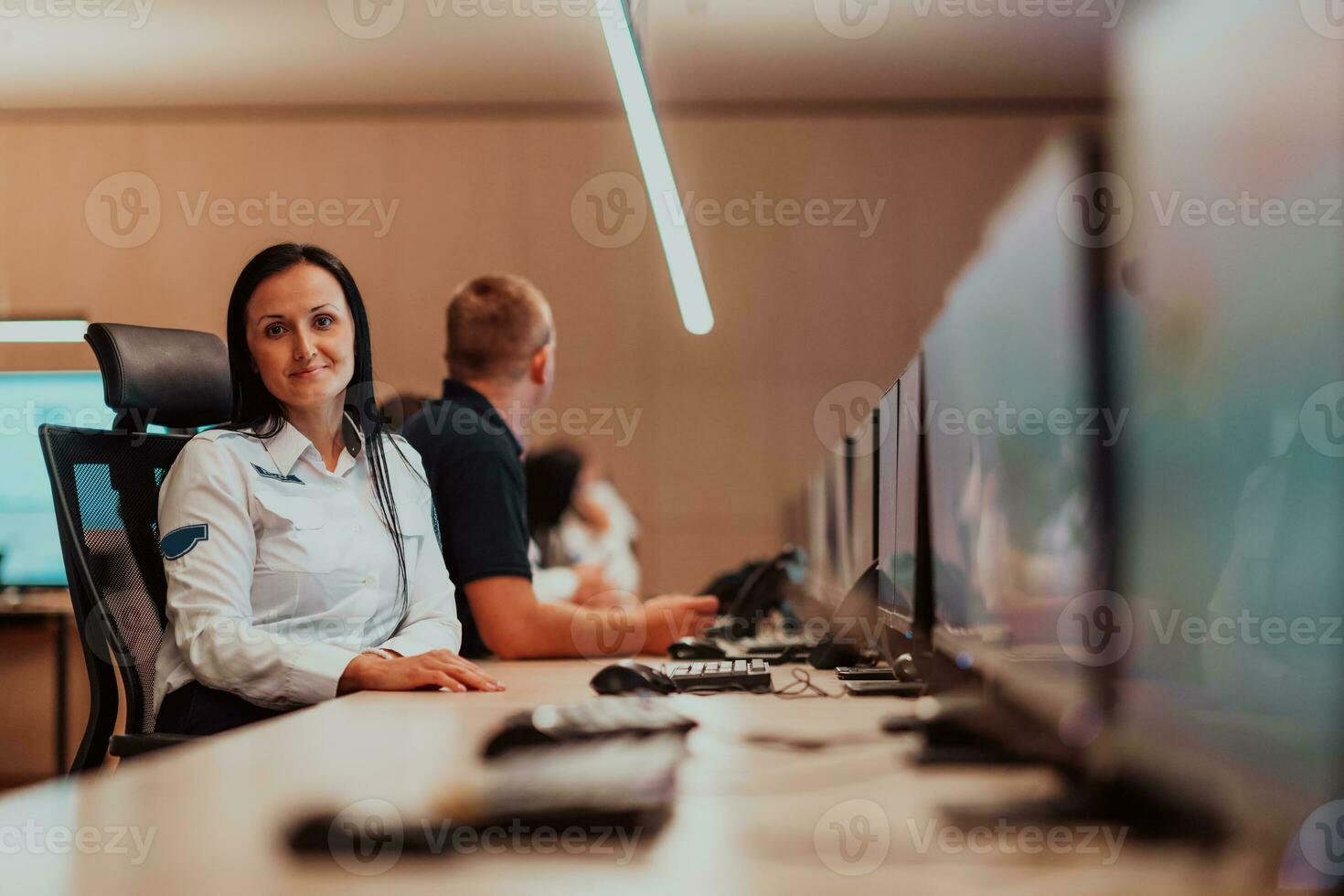 Female security operator working in a data system control room offices Technical Operator Working at workstation with multiple displays, security guard working on multiple monitors photo