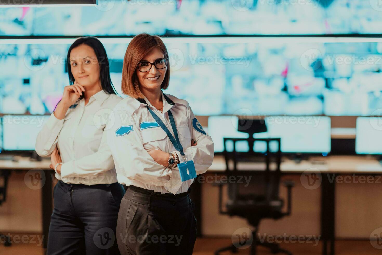 group portrait of female security operator while working in a data system control room offices Technical Operator Working at workstation with multiple displays, security guard working on multiple mon photo